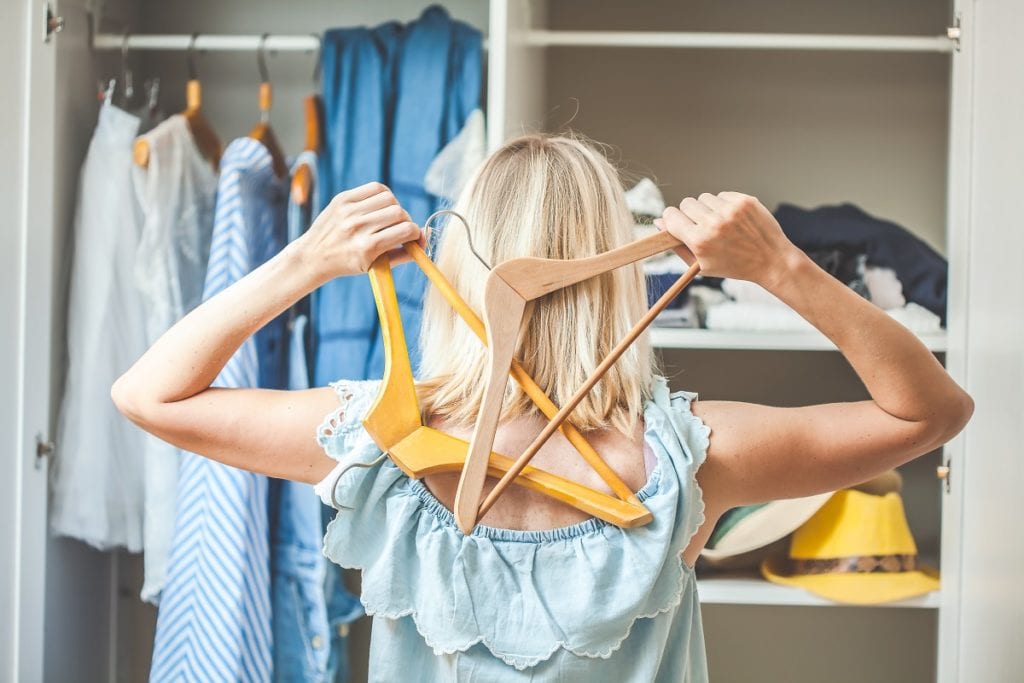 How to Revamp Old Clothes - girl near a wardrobe with clothes can not choose what to wear. Heavy Choice Concept has nothing to wear