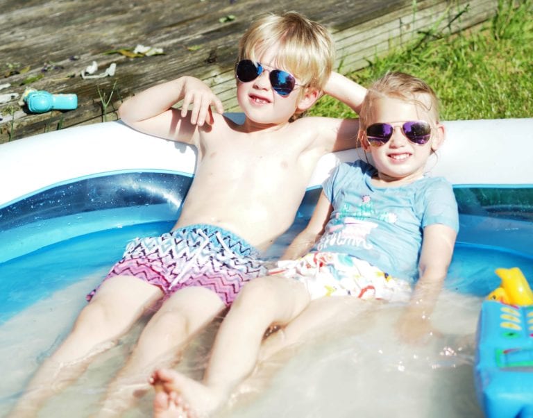 Our Summer Holiday Bucket List 2019 - Logan and Aria in the paddling pool relaxing with sunglasses on