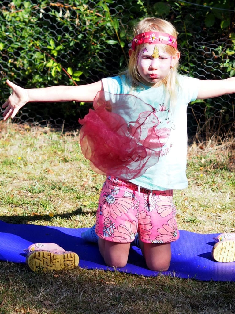 Aria blowing out a scarf during the Magical Yoga Tree session