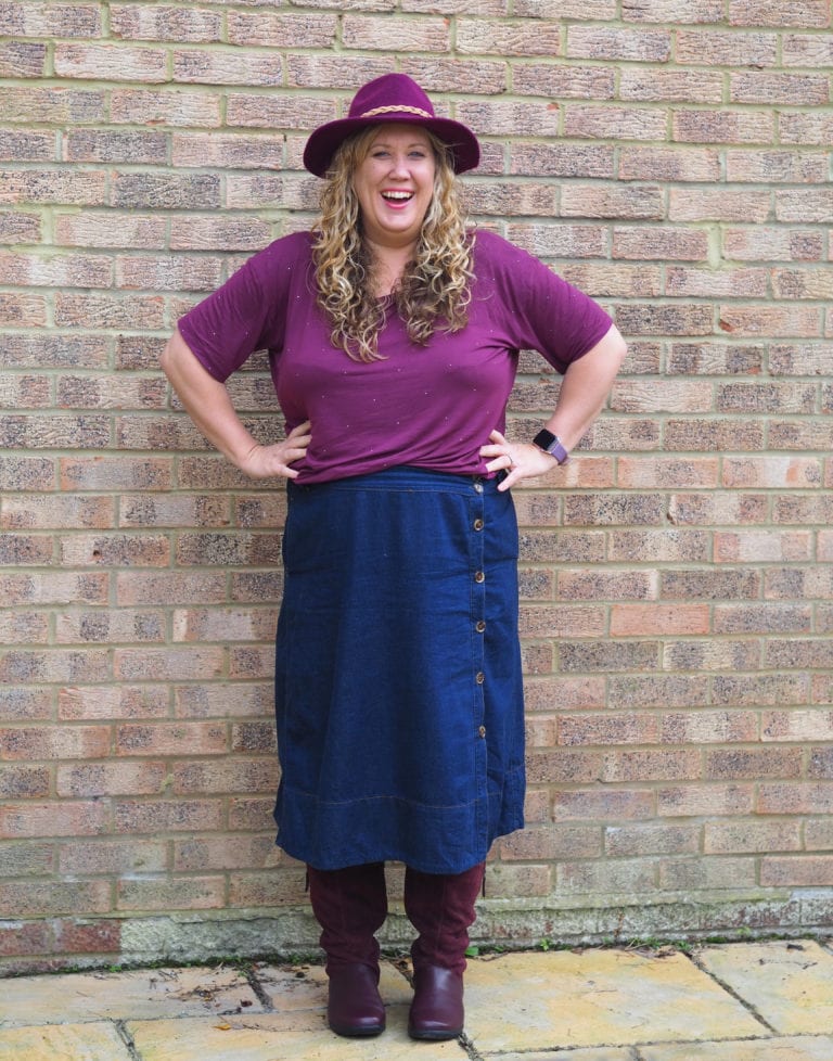 A picture of me laughing wearing a maroon top, denim skirt and maroon hotter boots