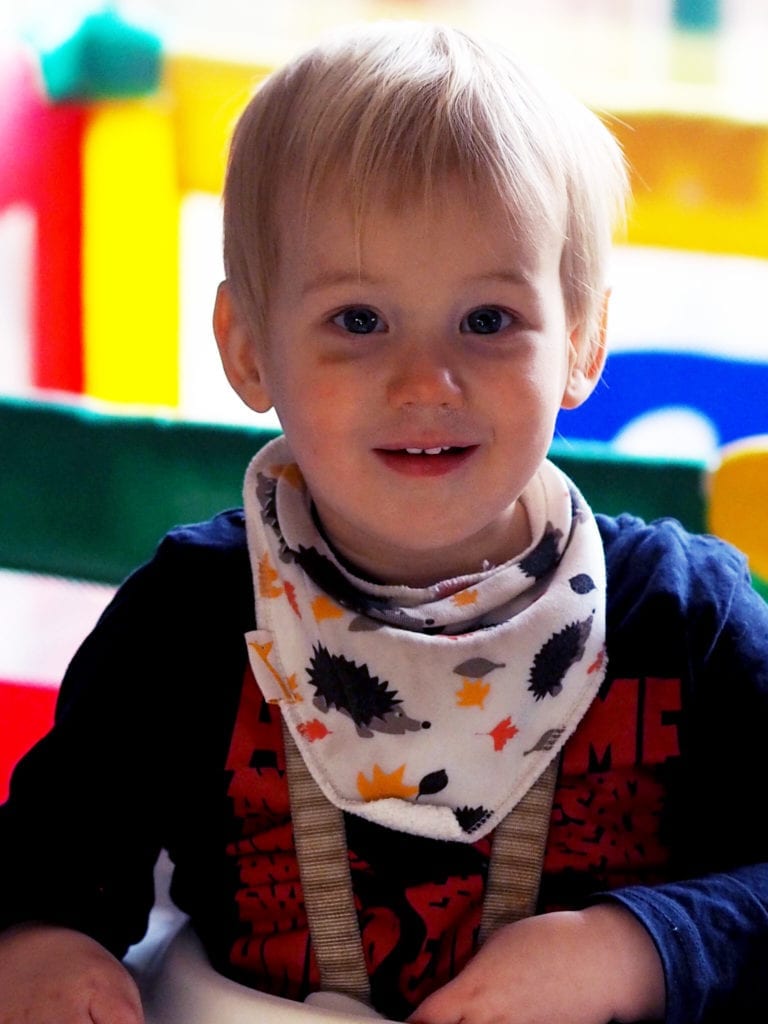 A picture of Bodhi smiling in his highchair