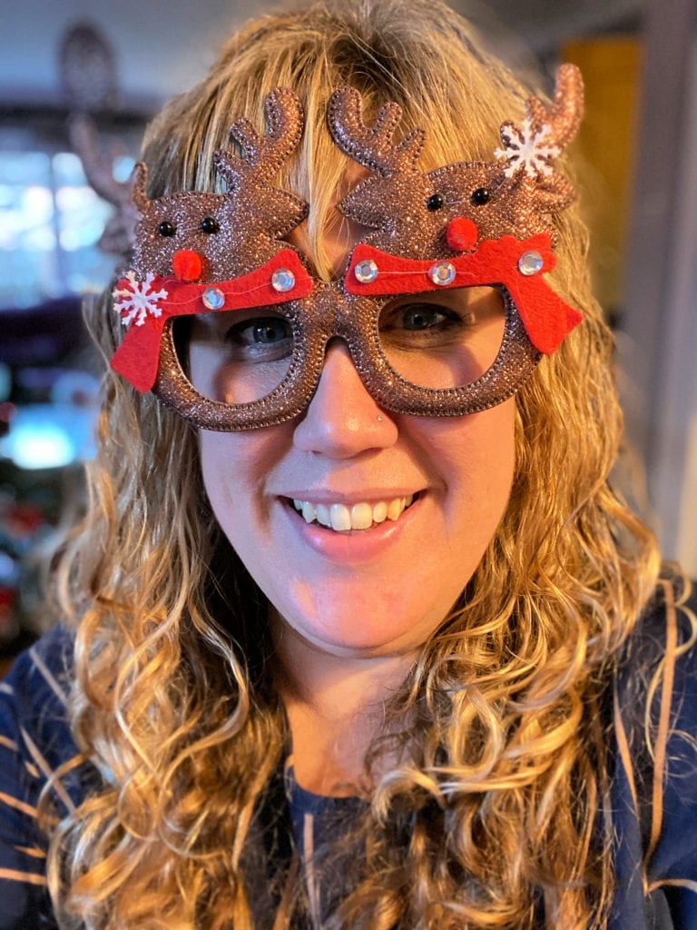 Picture of me wearing Christmas glasses in the shape of reindeer