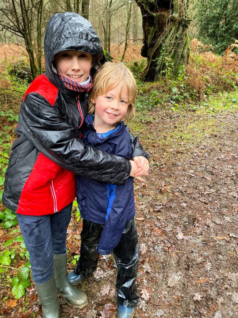 Logan and his cousin very wet in their waterproofs in the woods