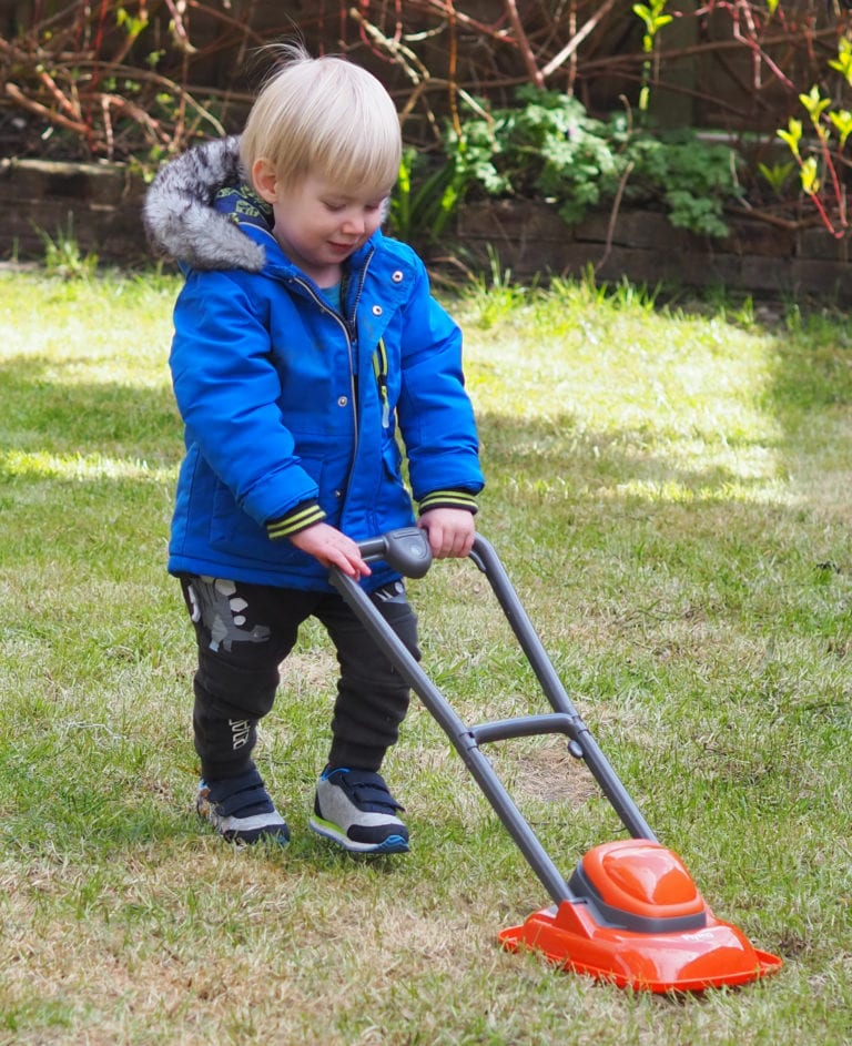 Bo playing with the Casdon lawnmover