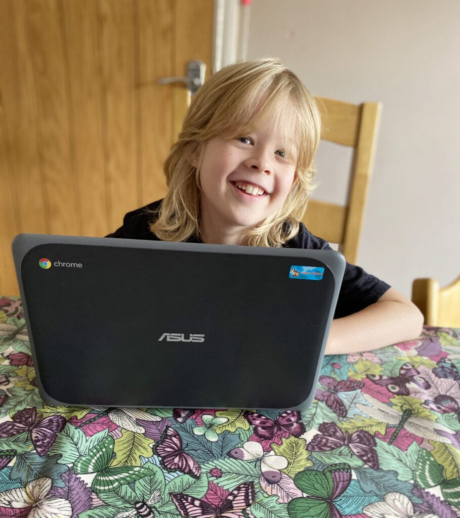 Atom Learning - Filling in the Gaps in your Child's Learning. Picture of a child smiling over the top of a laptop. 