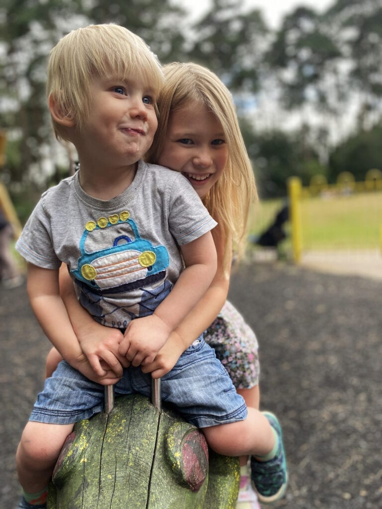 Bo and Aria sat on a frog at the park