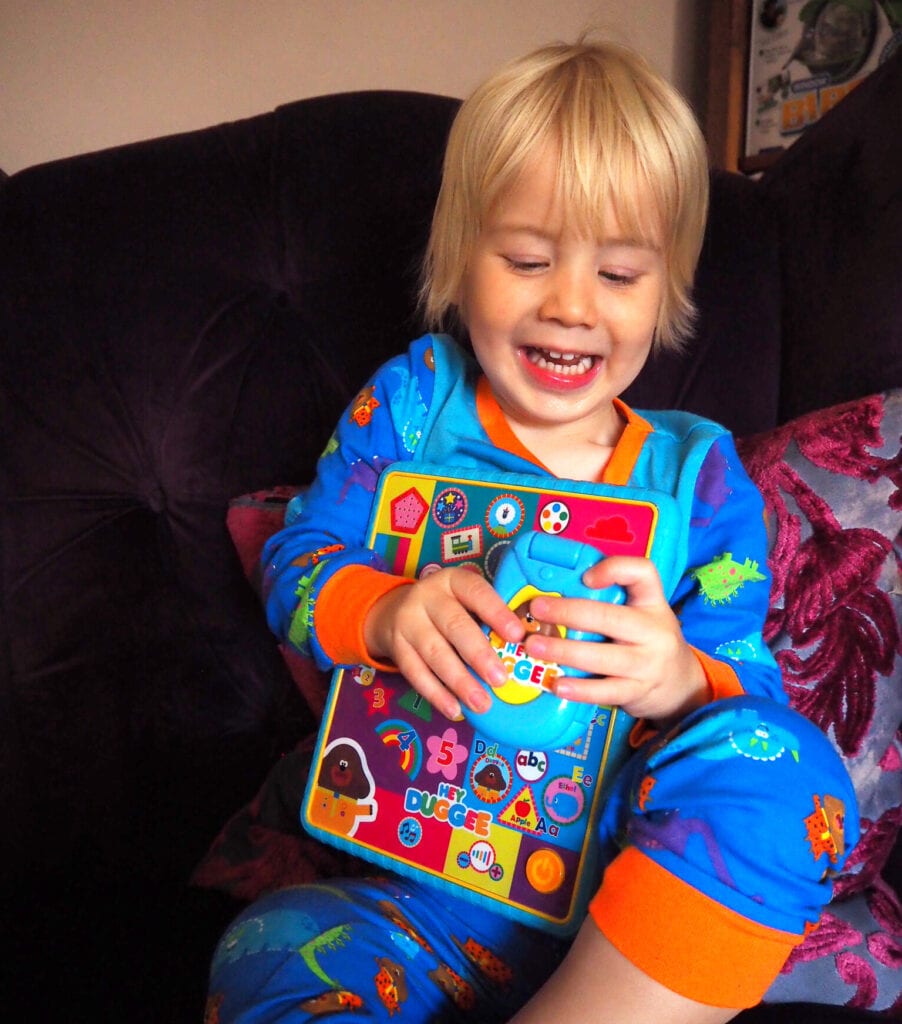 Bo smiling and delighted with his Hey Duggee toys